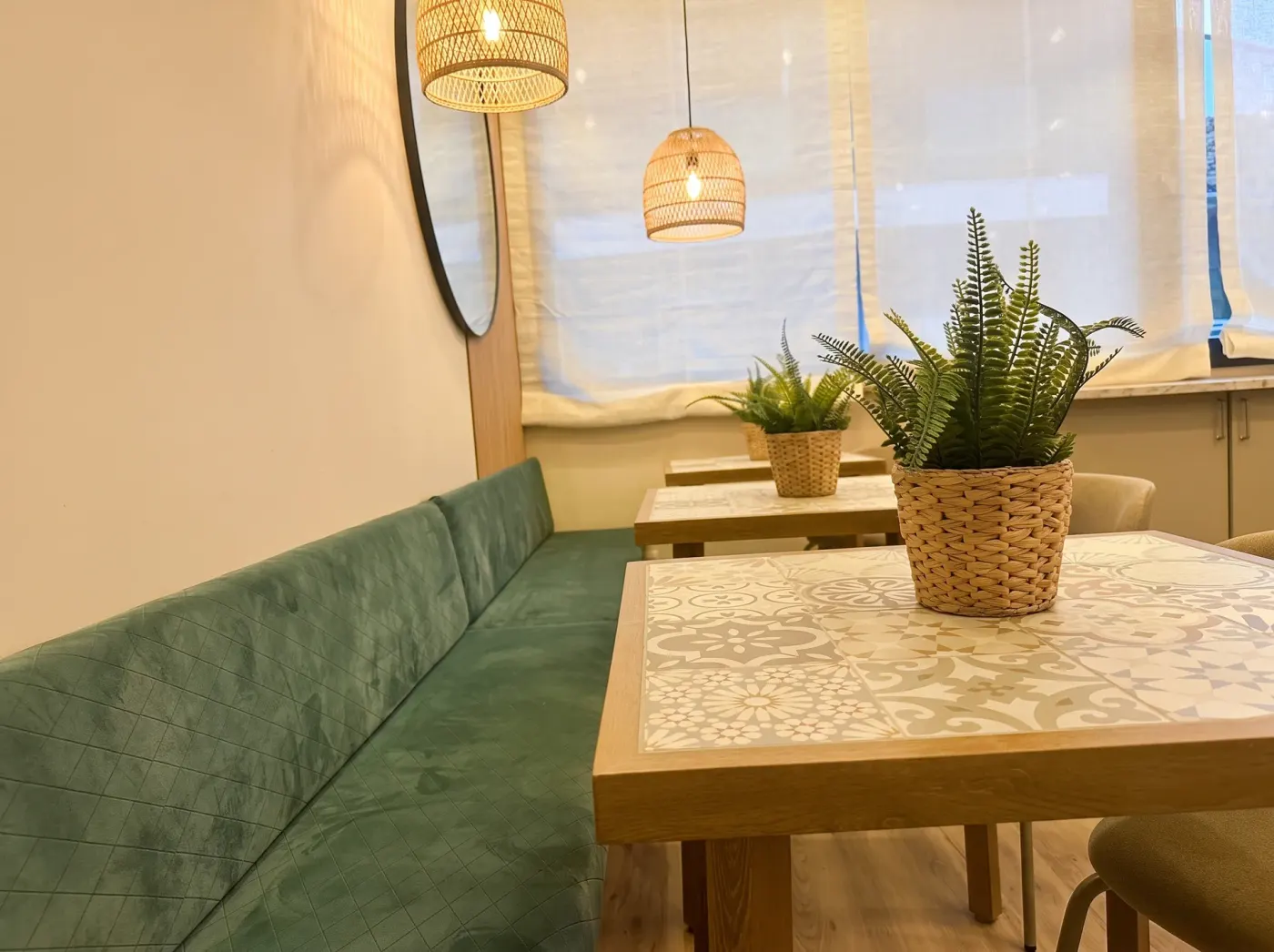 Banco tapizado en verde y mesa de azulejo en la zona de desayuno