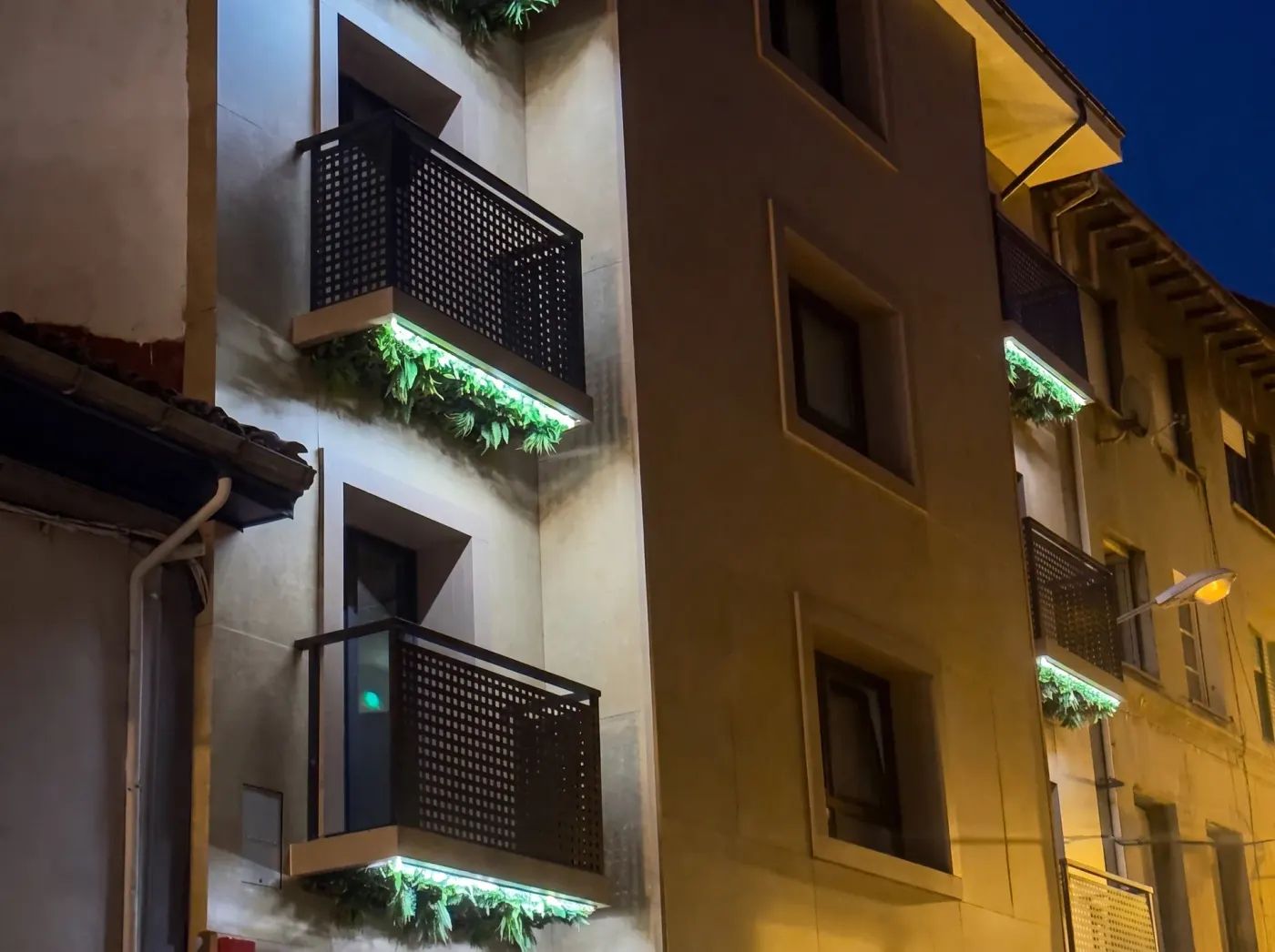 Balcones con jardineras iluminadas en la fachada del hotel