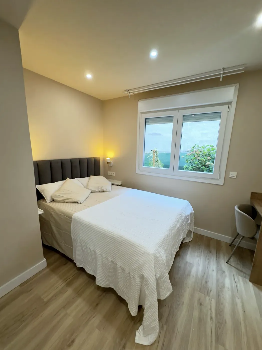 Dormitorio de la habitación sin barreras, en planta baja, con cama de matrimonio y ventana