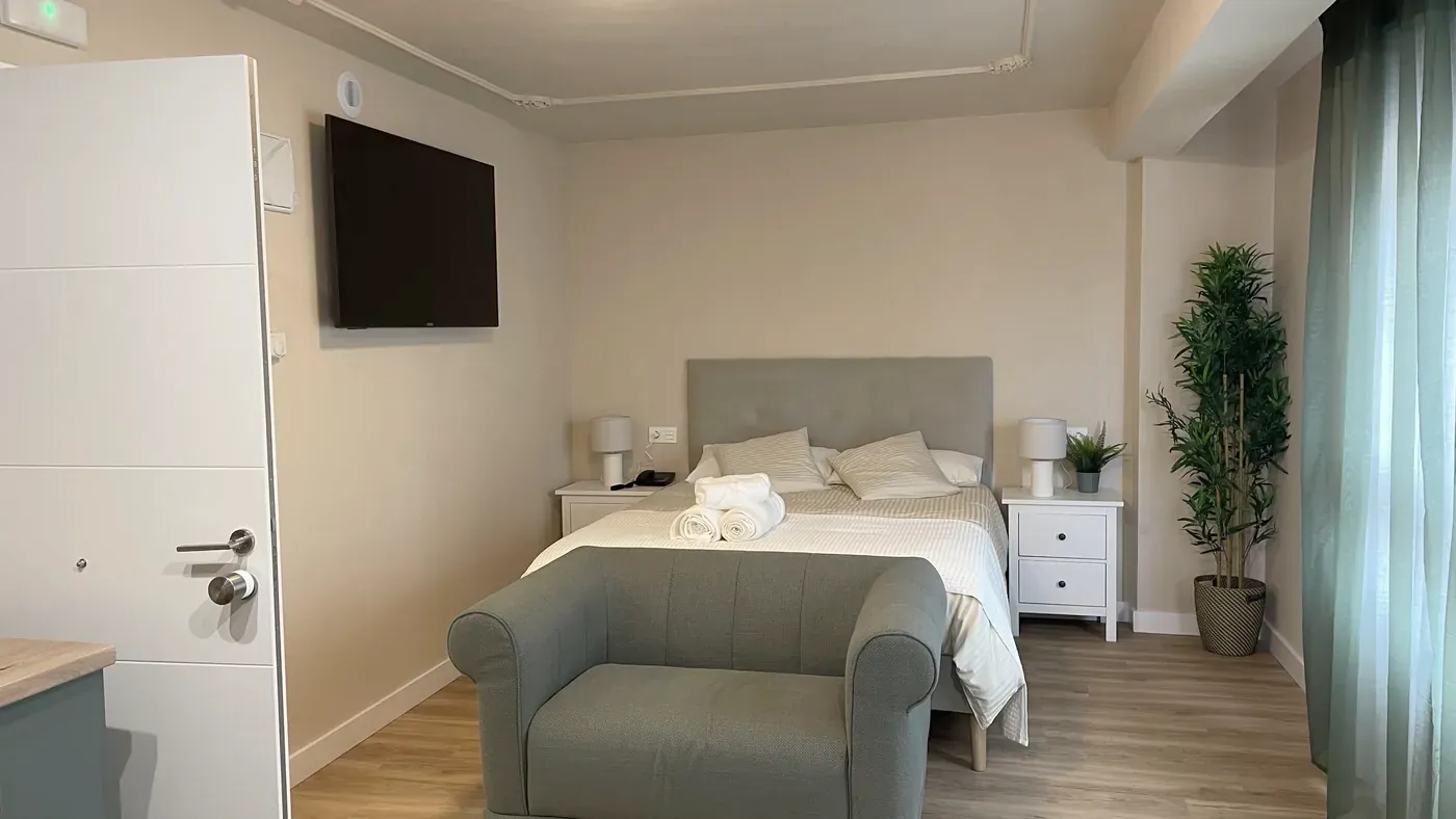 Cama y zona de estar de la suite, con sofá